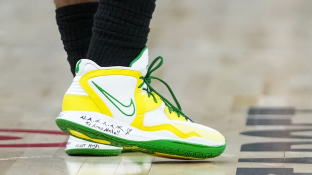View of white, yellow, and green Kyrie Infinity shoes.